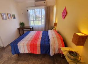 - une chambre avec un lit coloré et une fenêtre dans l'établissement Adventure Inn La Paz, à La Paz