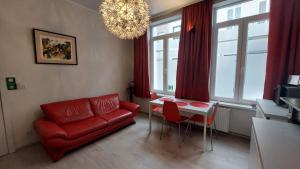 - un salon avec un canapé rouge et une table dans l'établissement Albert Studio's, à Malines
