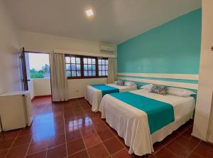 a room with two beds and a window at Calypso Beach Hotel by The Urbn House Santo Domingo Airport in Boca Chica