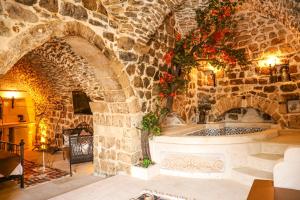 a stone room with a stone wall with a fireplace at Nostalji in Mardin