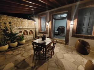 a room with a table and chairs and a stone wall at Evanthia's Stone House in Koilani