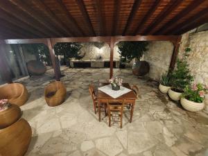 a patio with a table and chairs on a stone patio at Evanthia's Stone House in Koilani