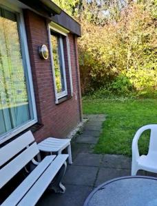 a white bench sitting outside of a house at Derbyallround in Herkingen