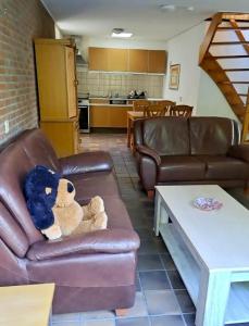 un osito de peluche sentado en un sofá en una sala de estar en Derbyallround, en Herkingen