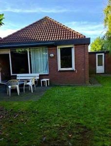 a house with a table and a bench in the yard at Derbyallround in Herkingen