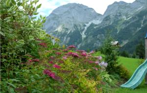 einen Garten mit Blumen und Bergen im Hintergrund in der Unterkunft Apartment Tennengebirge in Sankt Martin am Tennengebirge