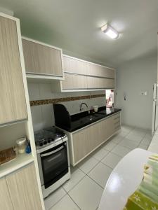 uma cozinha com um lavatório e um fogão forno superior em Apartamento no bairro universitário em Caruaru