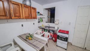 a small kitchen with a table and a sink at Casa Areal Boipeba in Ilha de Boipeba