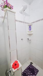 a bathroom with a toilet with a red flower on it at Casa Areal Boipeba in Ilha de Boipeba +19 photos