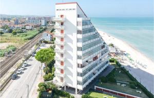 a tall white building next to a beach at Casa Mary in Marotta