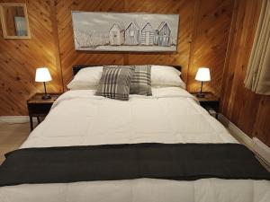 ein Schlafzimmer mit einem großen weißen Bett mit zwei Lampen in der Unterkunft Fireside - Waterfront Resort Style Executive Cottage in Kawartha Lakes