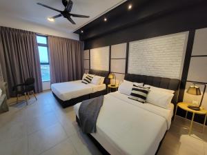 a hotel room with two beds and a ceiling fan at Atlantis Residences 1BR By 360 HOME in Melaka