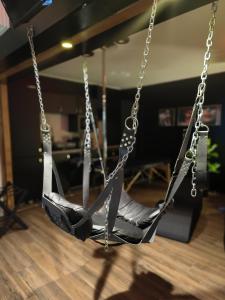 a swing in a living room with a wooden floor at La loveroom bdsm de Nice " la chambre luxe des désirs " in Nice