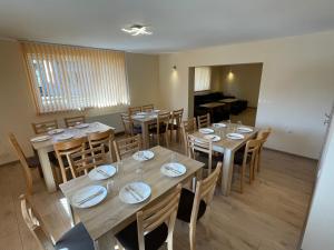 comedor con mesas y sillas de madera en Villa Stoyanovata Kashta, en Samokov