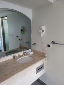 baño con lavabo y espejo grande en Real La Viga Motel en Ciudad de México