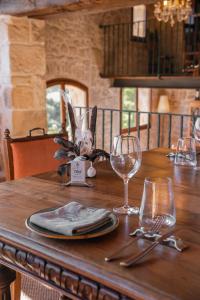 une table en bois avec des assiettes et des verres dans l'établissement Hotel Hort De Fortunyo, à Arnés