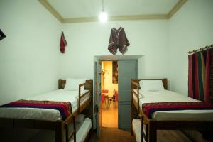 a room with two beds and a butterfly on the wall at Hostel Cultural Pata y Perro in Tarija