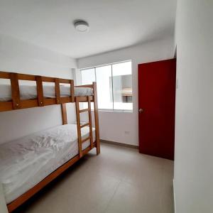 a bedroom with two bunk beds and a window at Apartamentos Punta Hermosa in Punta Hermosa