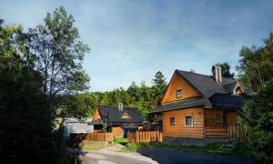 ein großes Holzhaus mit schwarzem Dach in der Unterkunft Chalupa Goral in Jezersko