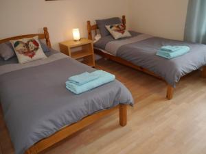 een kamer met 2 aparte bedden en handdoeken bij Arakhova in Kirkcudbright