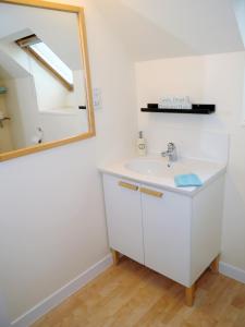 een badkamer met een witte wastafel en een spiegel bij Arakhova in Kirkcudbright