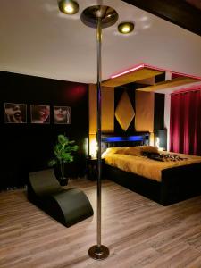 - une chambre avec un lit et une chaise dans l'établissement La loveroom bdsm de Nice " la chambre luxe des désirs ", à Nice