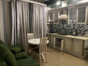 a small kitchen with a table and a table and chairs at Fontush Boutique Hotel in Ivano-Frankivsk