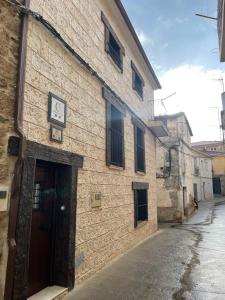 un edificio de ladrillo con un reloj a un lado en Apartamento rural jama, en Cilleros