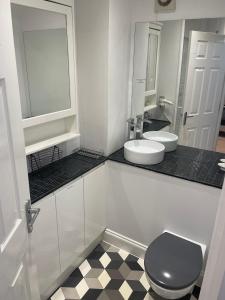 ein Badezimmer mit einem WC, einem Waschbecken und einem Spiegel in der Unterkunft Entire Home between London and Kent- Mulberry House in Kent