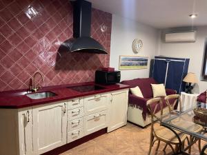 a kitchen with a sink and a living room with a couch at Apartamento rural jama in Cilleros