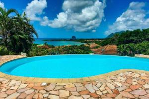 a swimming pool with a view of the ocean at Villa Aloes: Vue mer et calme à 2 pas de la plage in Le Diamant