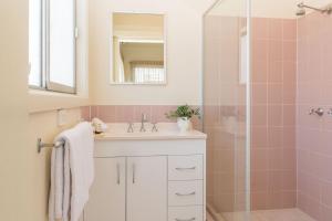 a bathroom with a sink and a shower at Pacific Motel 02 in Forster +8 photos