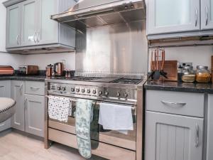 a kitchen with a stainless steel stove and white cabinets at Yewdale in Lytham St Annes