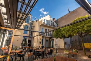 un patio avec des tables et des chaises et un bâtiment dans l'établissement Penzion Na Náměstí, à Dvůr Králové nad Labem