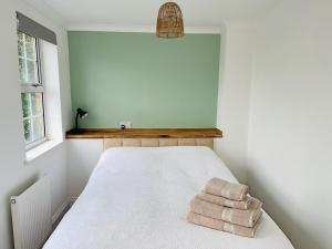 ein Schlafzimmer mit einem Bett mit zwei Handtüchern darauf in der Unterkunft Entire Home between London and Kent- Mulberry House in Kent