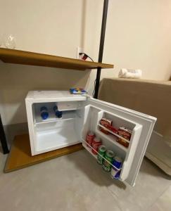 a small refrigerator with drinks inside of it at Hotel Goiano in Estreito