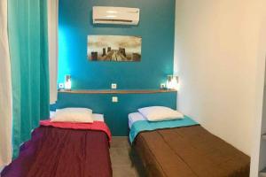 2 Betten in einem Zimmer mit blauen Wänden in der Unterkunft F3 proche mer Pointe du Bout Trois Ilets in Les Trois-Îlets