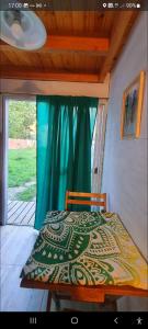 a bed in a room with a window at Sur tiny house in El Bolsón