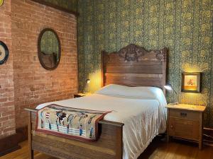 een slaapkamer met een bed en een bakstenen muur bij Gable House Bed and Breakfast Inn in Durango