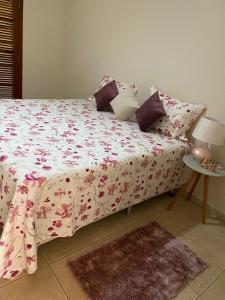 um quarto com uma cama com um edredão floral cor-de-rosa em Espacin Maricris-28 min. Thermas Sao Pedro em Piracicaba