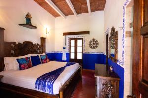 1 dormitorio con 1 cama con paredes azules y blancas en Hacienda Maria Eugenio, en Guanajuato