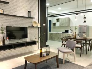 une cuisine et un salon avec une télévision et une table dans l'établissement Atlantis Residences By 360 HOME, à Malacca