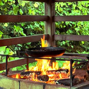 a pan over a fire in a grill at Casa do Rio Alva in Arganil