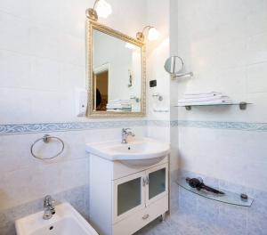 a white bathroom with a sink and a mirror at Beach apartment Demi in Split