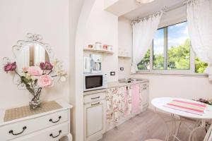 una cucina con armadi bianchi, tavolo e finestra di Beach apartment Demi a Spalato (Split)