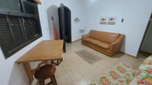 un salon avec un canapé, une table et une chaise dans l'établissement Chalé Pé na Areia em Rio das Ostras, à Rio das Ostras