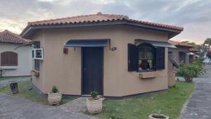 une petite maison avec une fenêtre et une porte dans l'établissement Chalé Pé na Areia em Rio das Ostras, à Rio das Ostras