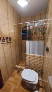 une salle de bain avec des toilettes blanches dans une chambre dans l'établissement Chalé Pé na Areia em Rio das Ostras, à Rio das Ostras 29 autres photos