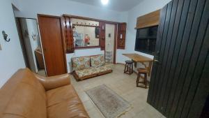 un salon avec un canapé et une table dans l'établissement Chalé Pé na Areia em Rio das Ostras, à Rio das Ostras