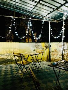 una mesa y sillas en una habitación con luces en Hostel Stari Grad, en Novi Sad